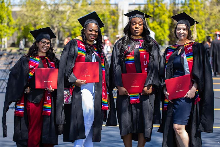 four graduates showing off their IU degrees.