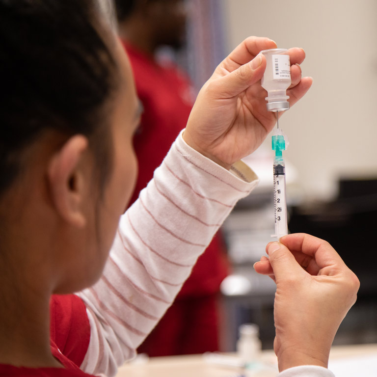 Nursing student holding syringe